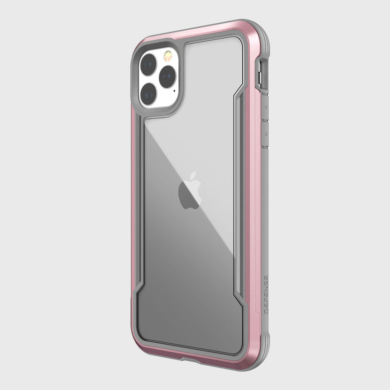 The Raptic SHIELD iPhone 11 Pro Max case features a clear design with a pink and gray bumper for drop protection. It showcases the Apple logo against a white background, blending style and safety, and includes aluminum alloy elements for enhanced durability.
