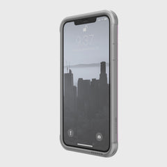 The Raptic SHIELD iPhone 11 Case in sleek grey showcases a cityscape wallpaper with the time 9:37 and date Tuesday, September 26. Made of durable aluminum alloy, it provides protection while being compatible with wireless charging.