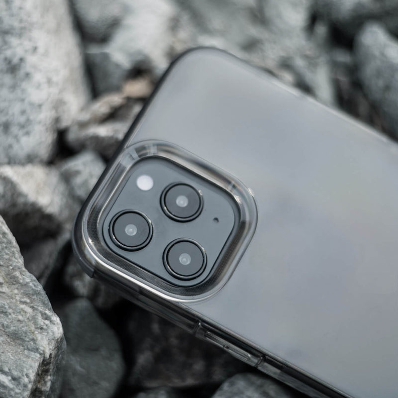 The iPhone 12 Pro Max is sitting on top of rocks with Raptic Clear case for drop protection.