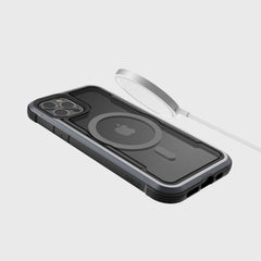 A Raptic SHIELD PRO MAGNET case encases an iPhone 12 on a plain background, while a MagSafe charger hovers above, providing seamless power and reliable drop protection.