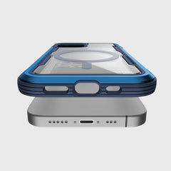 The Raptic iPhone 12 & iPhone 12 Pro Case - SHIELD PRO MAGNET in blue, featuring a clear back and enhanced drop protection, is shown levitating above a silver phone.