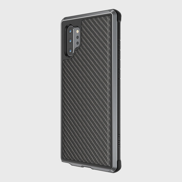 The Raptic Samsung Galaxy Note 10+ Case in Lux Black Carbon features a carbon fiber pattern and machined aluminum bumper, highlighting the rear camera on a plain background. It offers military-grade drop protection and wireless charging compatibility, merging style with durability.