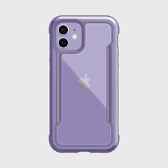 The Raptic iPhone 12 Raptic Shield case in purple features a logo-revealing clear back and offers military-grade drop protection for the camera and edges. Designed on a white background, it's compatible with wireless charging, blending convenience with style.