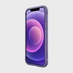 The iPhone 12 Raptic Shield case in purple, crafted by Raptic, showcases a circular abstract wallpaper and is angled slightly left on a plain background. Its machined aluminum bumper offers military-grade drop protection, combining sleekness with sturdiness.
