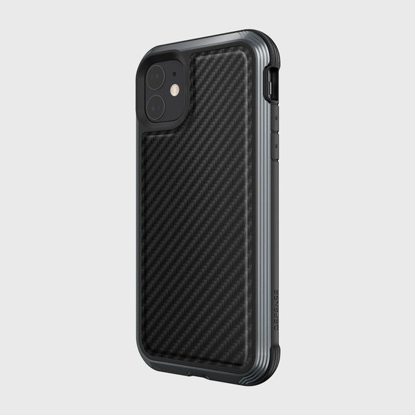 A Raptic LUX black carbon fiber case on an iPhone 11 with dual cameras against a light gray background. The impact-resistant design is wireless charging compatible, offering both style and functionality.