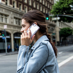 A woman talking on her iPhone SE/8/7 Case - SHIELD by Raptic on the street.
