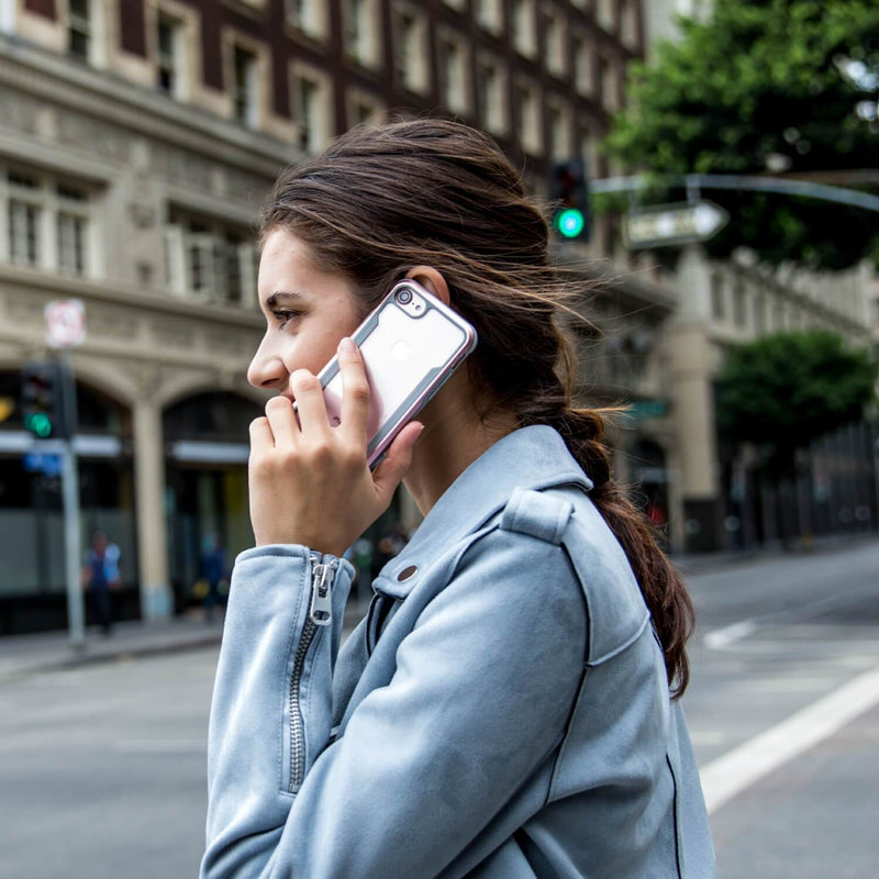 A woman talking on her iPhone SE/8/7 Case - SHIELD by Raptic on the street.