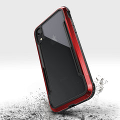 A rugged red and black iPhone XR case from Raptic, called SHIELD, lands on a surface, stirring up dust. It offers military-grade drop protection for durability and superior shock absorption against unexpected falls.