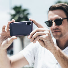 A man in sunglasses is taking a picture of his Raptic iPhone XR Case - ULTRA.