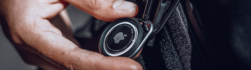 A person's hand is holding a button on a bag.