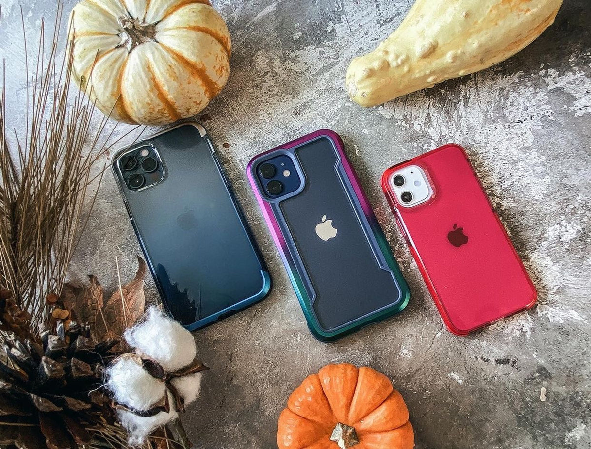 Three iphone 11 cases laying on a concrete surface.