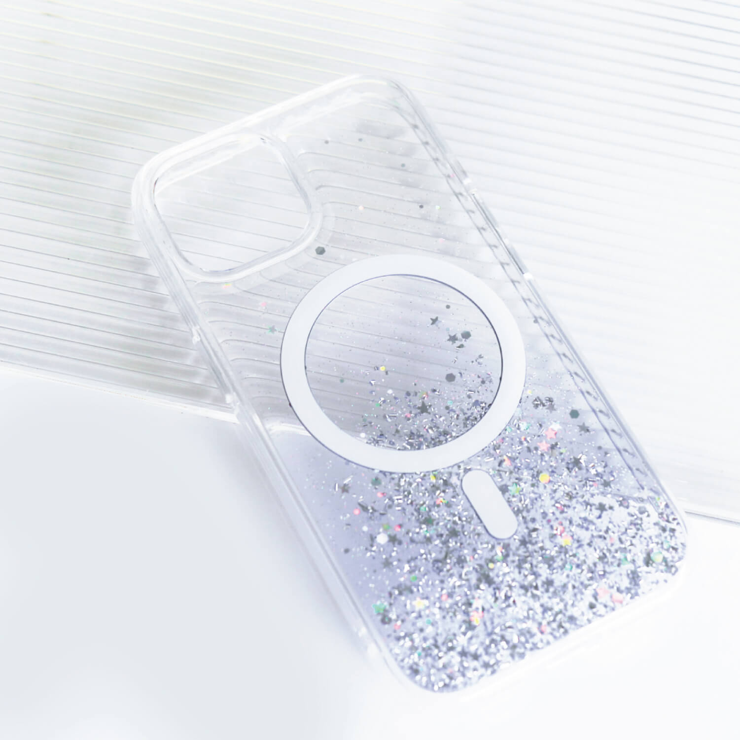 A clear iPhone 15 Starburst Glitter MagSafe Case - Bryten by Raptic with a wireless charging feature.