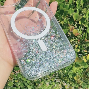 A person holding a clear glitter iPhone 15 Starburst Glitter MagSafe Case - Bryten by Raptic with wireless charging compatibility.