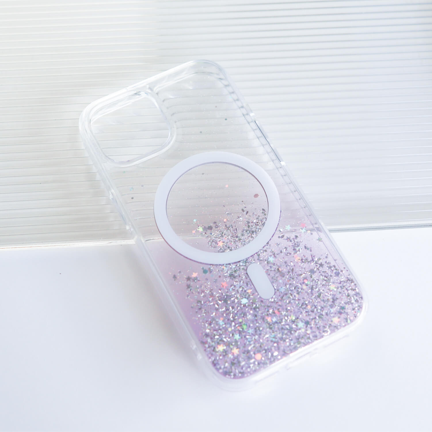 A purple glitter iPhone 15 Starburst Glitter MagSafe Case - Bryten by Raptic with a mirror on it.