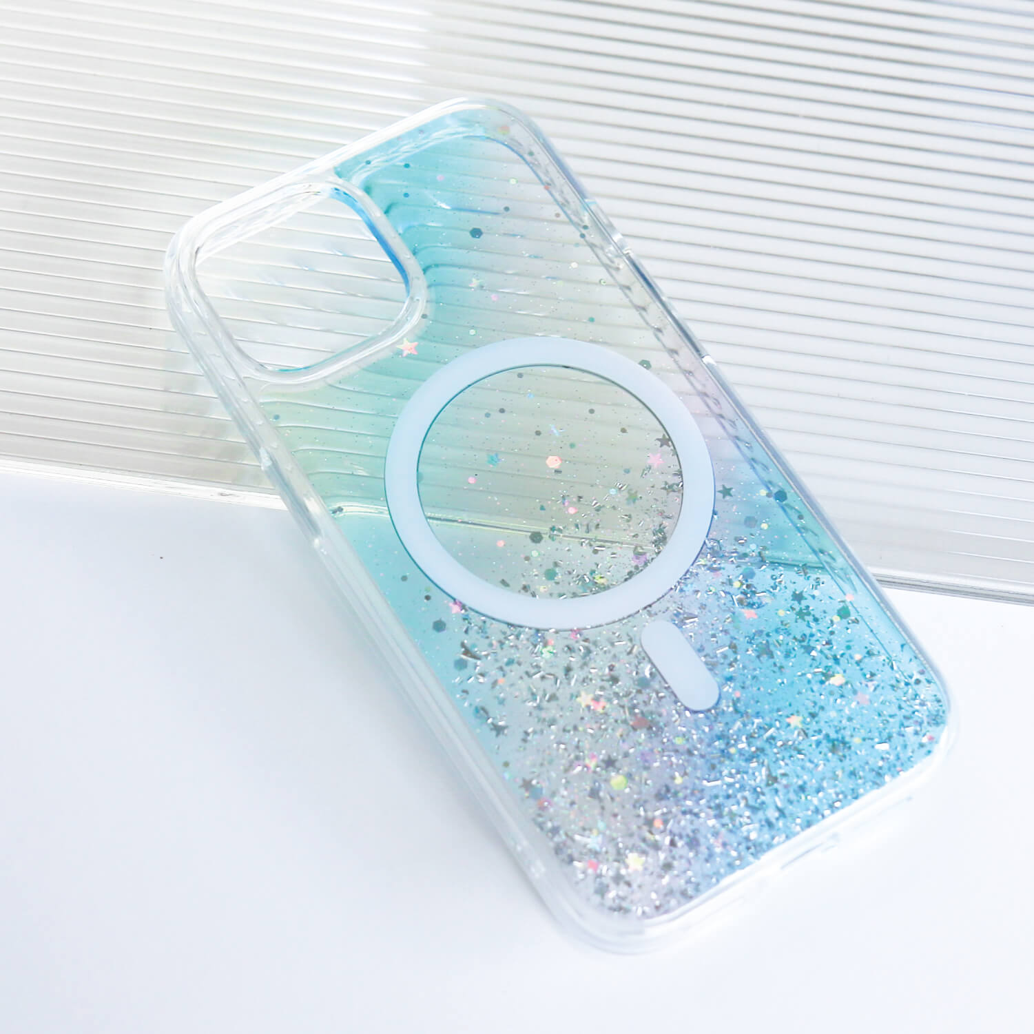 A iPhone 15 Starburst Glitter MagSafe Case - Bryten by Raptic with a blue glitter logo on it.