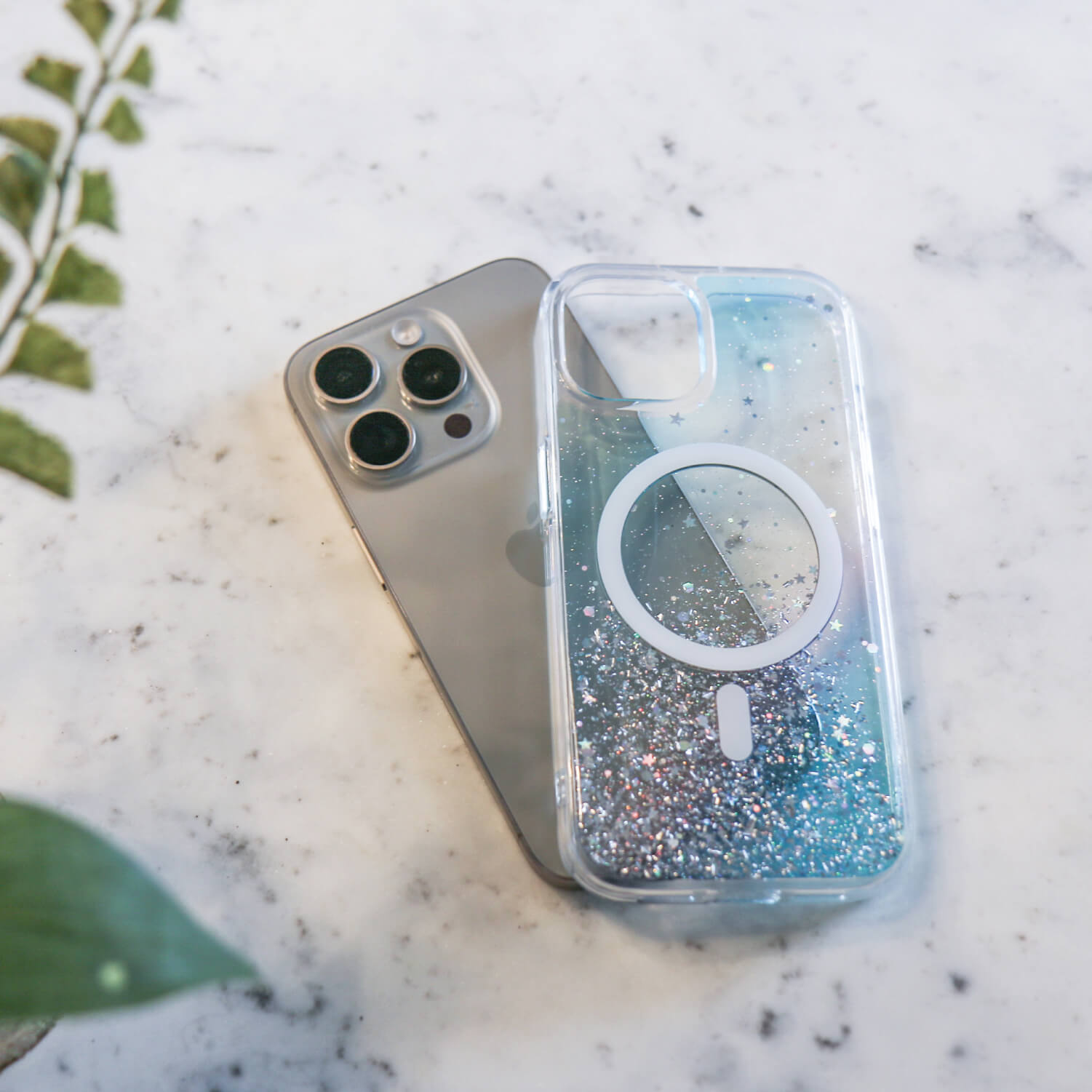 A Raptic phone case with a flower on it, compatible with wireless charging and MagSafe technology for iPhone 15 Pro Max. The product name is the iPhone 15 Starburst Glitter MagSafe Case - Bryten by Raptic.