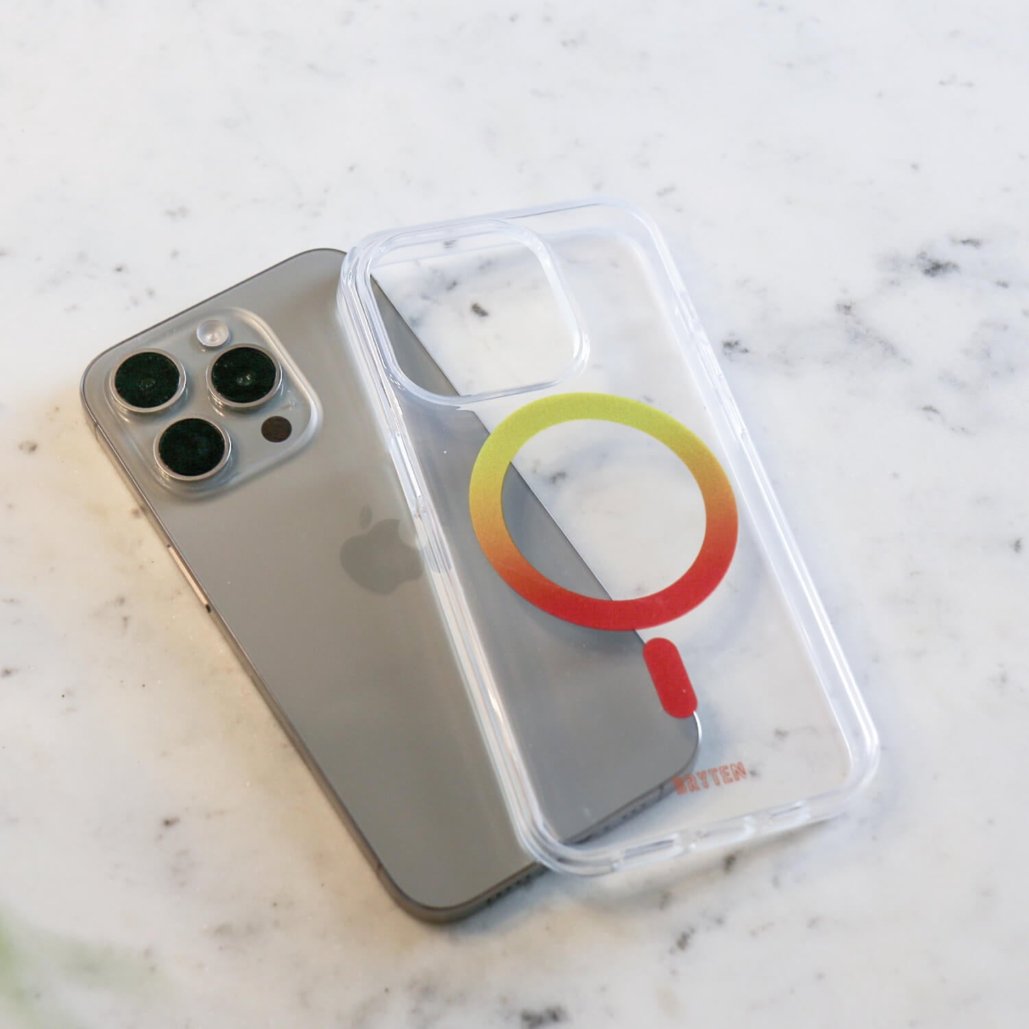 A clear iPhone 15 MagFx MagSafe Case with a colorful logo on it, featuring MagSafe for wireless charging by Bryten.