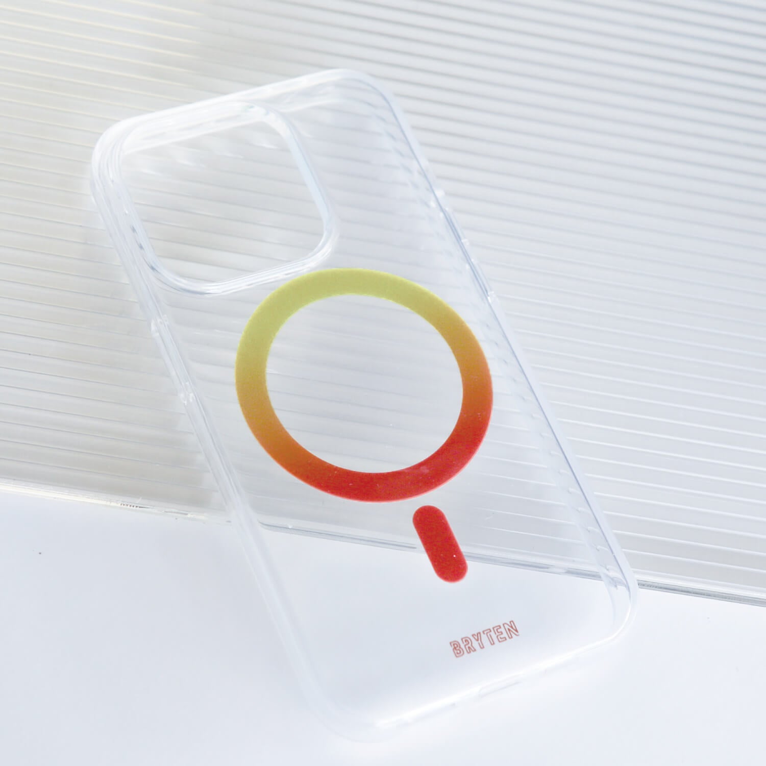 A clear iPhone 15 MagFx MagSafe case with a vibrant logo incorporating red, yellow, and blue colors - Bryten by Raptic.