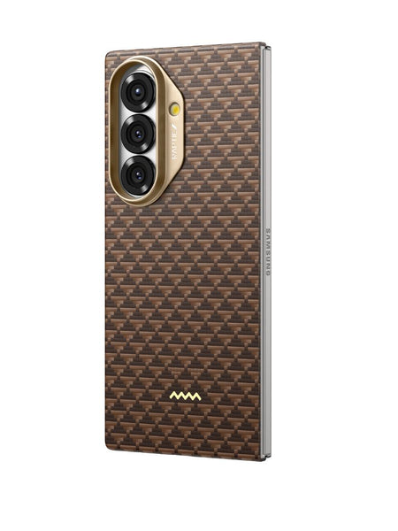 The Raptic Skin Origin Humble for Samsung Galaxy Z Fold 7 features a brown, textured aramid fiber carbon-fiber patterned back with a gold-rimmed triple rear camera cutout, a small gold logo at the bottom, and is MagSafe compatible.