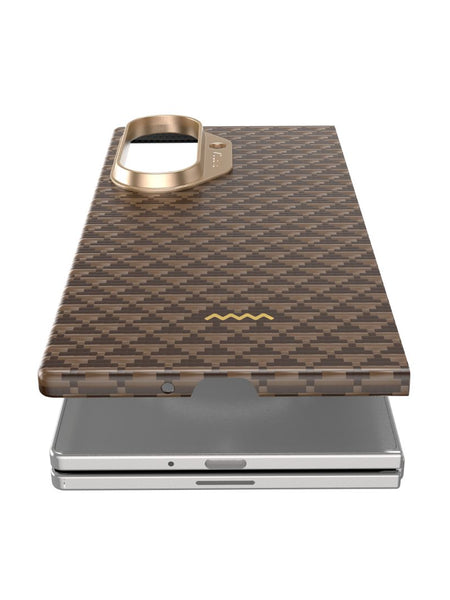 A close-up of the Raptic Samsung Galaxy Z Fold 7 - Skin Origin Humble case in brown aramid fiber with a gold camera ring, shown partially detached and MagSafe compatible.