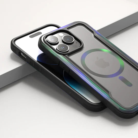 A smartphone with a triple-camera setup in an Raptic iPhone 15 Shield MagSafe Case - Shield 2.0, resting on a sleek, gray surface, highlighting its wireless charging capability.