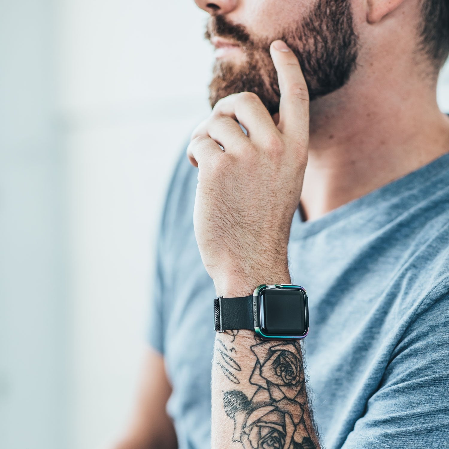 A man wearing a Raptic Apple Watch 42mm Case - EDGE with a machined anodized aluminum bumper and tattoos on his wrist.