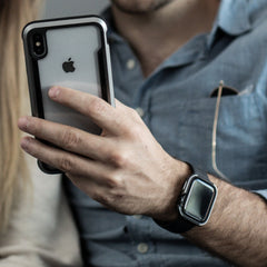 Someone wearing a Raptic Apple Watch 40mm Case - EDGE holds an iPhone in a scratch-protection case.