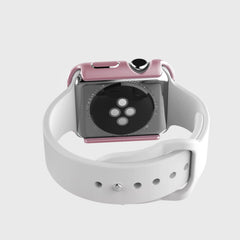 The Raptic Apple Watch Bumper provides scratch protection for the smartwatch with its pink anodized aluminum case and white band, elegantly displaying the heart rate sensor from the back.