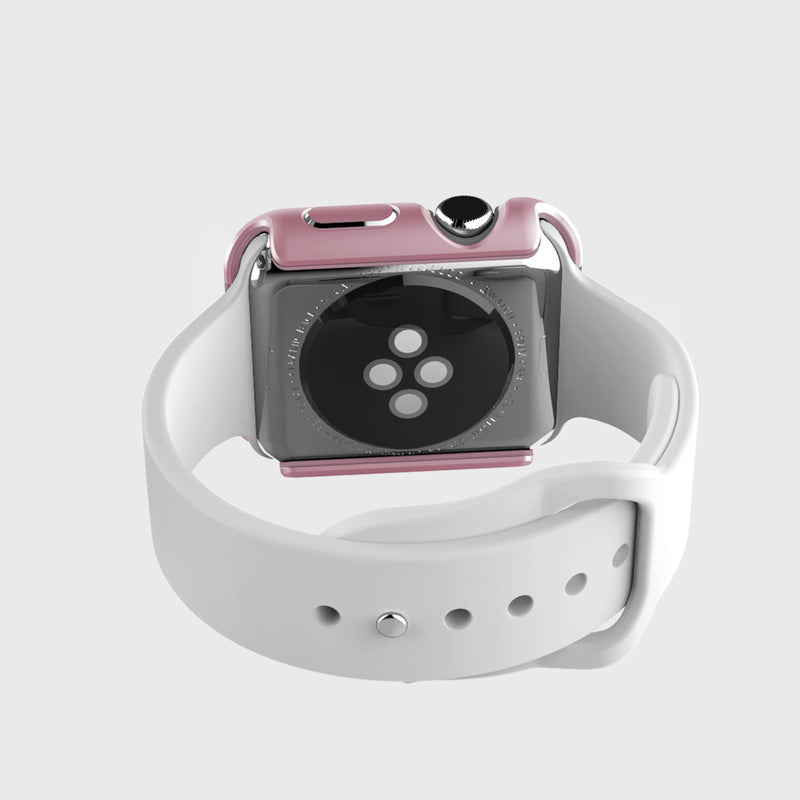The Raptic Apple Watch Bumper provides scratch protection for the smartwatch with its pink anodized aluminum case and white band, elegantly displaying the heart rate sensor from the back.
