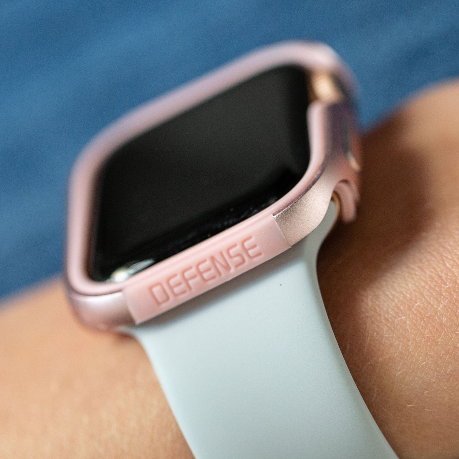 A woman's wrist with an Apple Watch 44mm Case - EDGE, protected by a Raptic machined anodized aluminum bumper, on it.