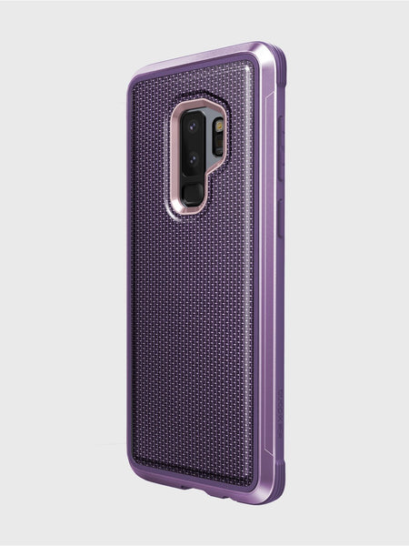 The X-Doria Samsung Galaxy S9 Plus Case Raptic Lux in purple features a textured back, precise cutouts for the camera and fingerprint sensor, and is designed for wireless charging compatibility. The protective case is pictured on a Samsung Galaxy S9+ against a plain white background.