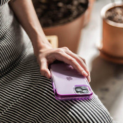 A woman holding a Raptic AIR iPhone 11 Pro Max Case, providing 13 foot drop protection.