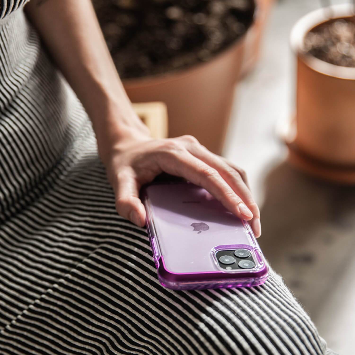 A woman holding a purple Raptic AIR iPhone 11 Case.
