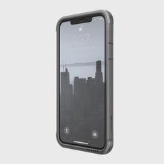 The iPhone 11 Pro Max, protected by a Raptic SHIELD case in rugged aluminum alloy, displays a vibrant cityscape wallpaper. The lock screen shows 9:37.