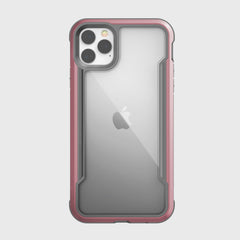 The Raptic SHIELD clear case, with red edges, fits the iPhone 11 Pro Max perfectly, showcasing the Apple logo and triple camera. Its aluminum alloy frame offers enhanced drop protection without sacrificing style.