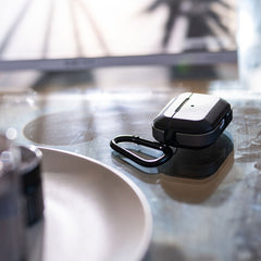 Raptic Trek Black case on Apple AirPods Pro showing the easy to slip on and off top, bottom and detachable carabiner.