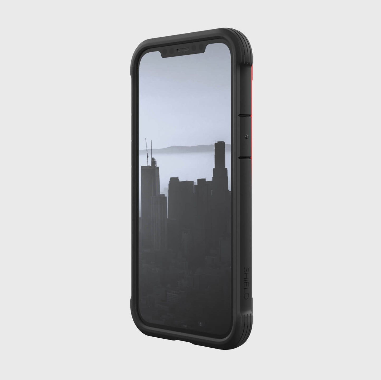 A black iPhone 12 Mini case - SHIELD by Raptic with a view of the city.