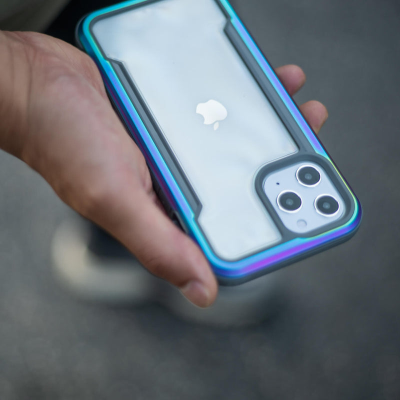 A person holding a Raptic iPhone 12 & iPhone 12 Pro Case - SHIELD in their hand, providing protection for their device.