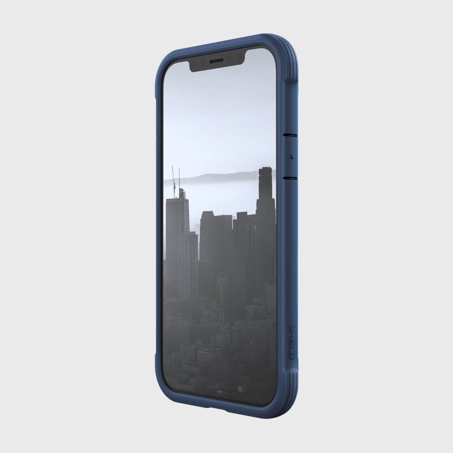 A blue Raptic SHIELD case for iPhone 12 Pro Max offering foot drop protection, featuring a view of the city.