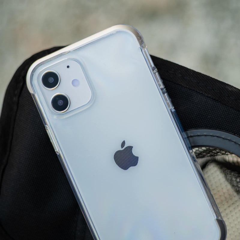 Showing a iPhone 12 Mini in a clear Raptic air case lying on top of a black bag