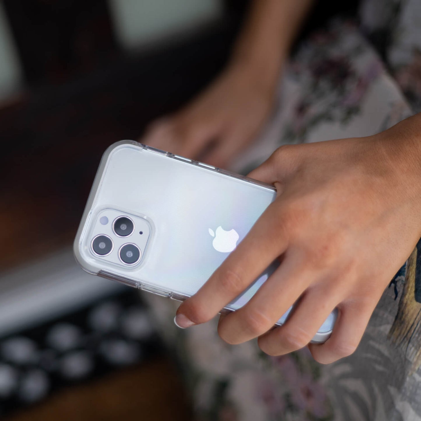 Showing a girl holding an iPhone 12 Pro in a clear Raptic Air case