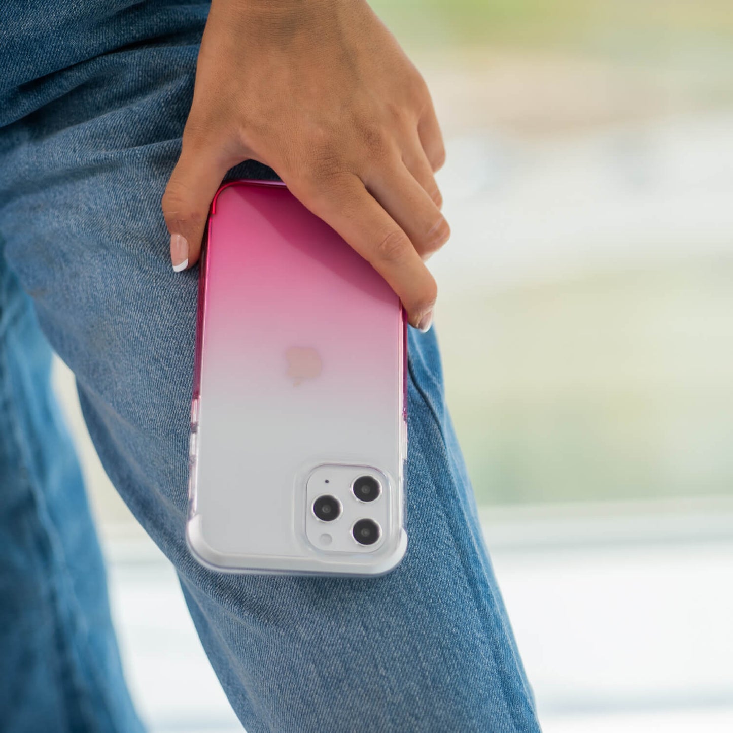 A woman showcasing a pink Raptic Air iPhone 12 & iPhone 12 Pro Case with exceptional 13-foot drop protection.