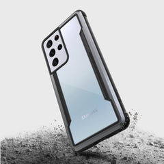 A drop protection phone case for Samsung Galaxy S21 Ultra, the X-Doria Samsung Galaxy S21 Ultra Case Raptic Shield Black with a camera on it.