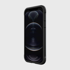 The Raptic SHIELD PRO MAGNET case for the iPhone 12 and iPhone 12 Pro, styled in black with geometric abstract wallpaper, offers drop protection and supports MagSafe chargers, enhancing the phone's sleek design against a plain background.
