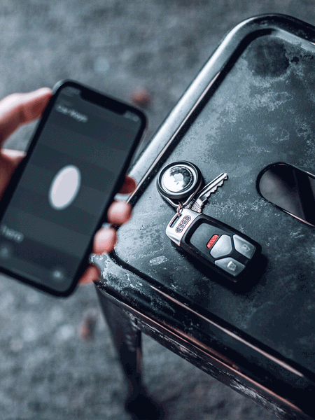 A man picking up Apple AirTags in a Raptic Link case to pair to his iPhone 