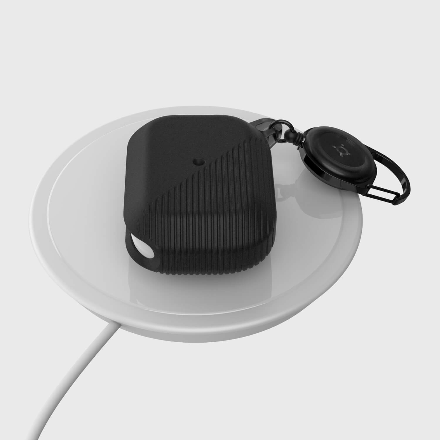A Raptic Apple AirPods Pro Case - RADIUS, protected by a silicone case, is sitting on top of a white plate.