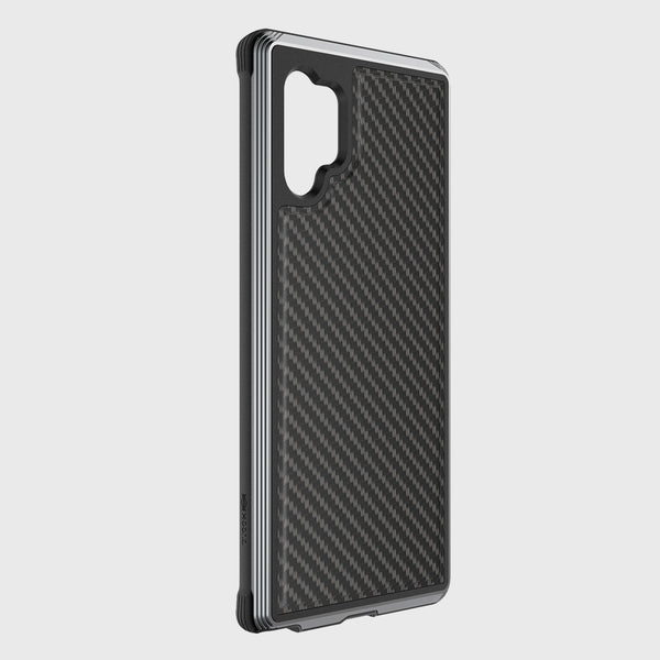 The Raptic Samsung Galaxy Note 10+ Case - Lux Black Carbon, with a camera lens cutout and machined aluminum bumper, provides military-grade drop protection. Set against a white background, it is also compatible with wireless charging.