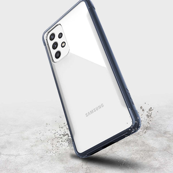 A Samsung Galaxy A53 smartphone with a Raptic Strong biodegradable, eco-friendly case standing upright on a concrete surface with a dynamic water splash effect near its base.