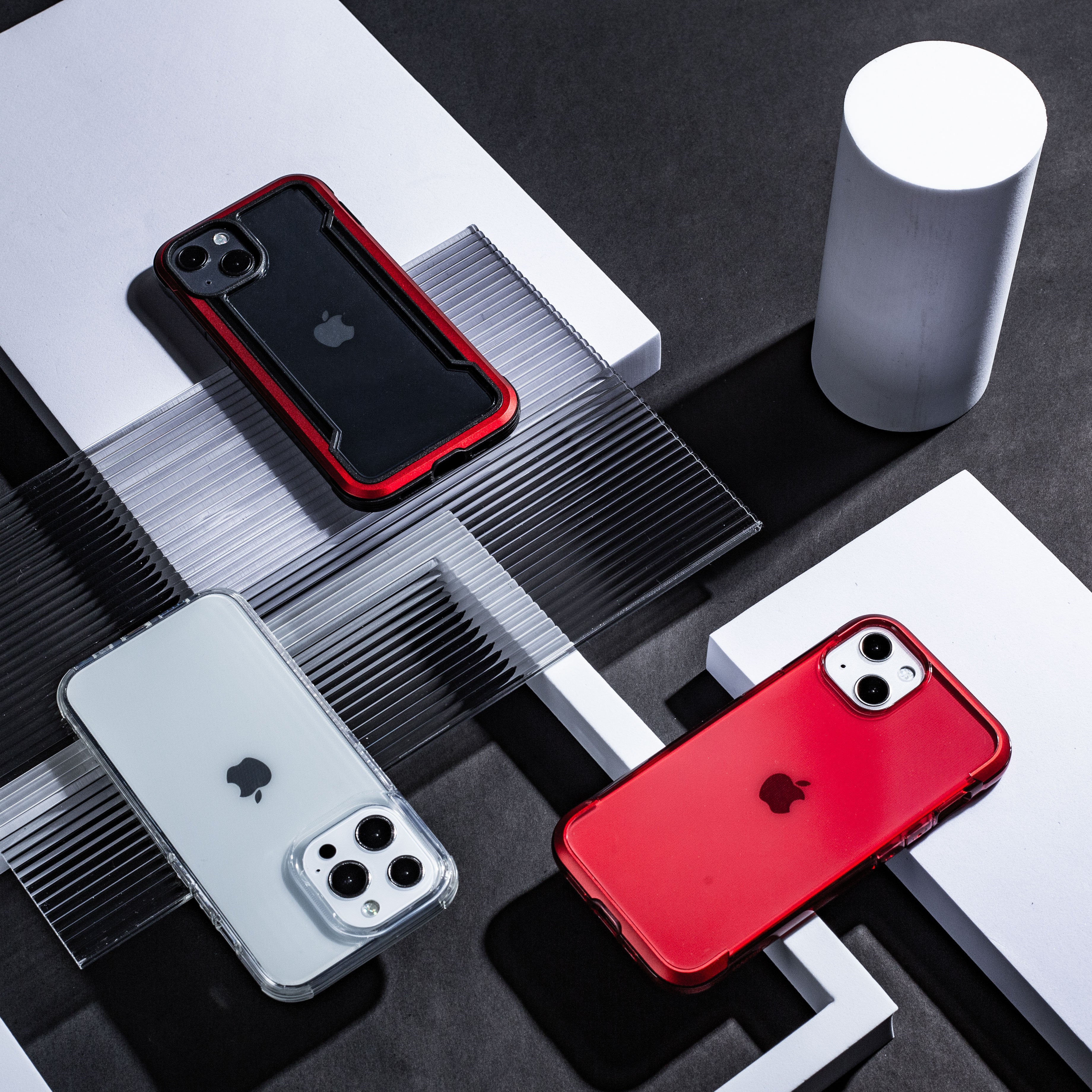 A red, black, and white iPhone 13 Pro Case - AIR by Raptic on a table with wireless charging compatibility.