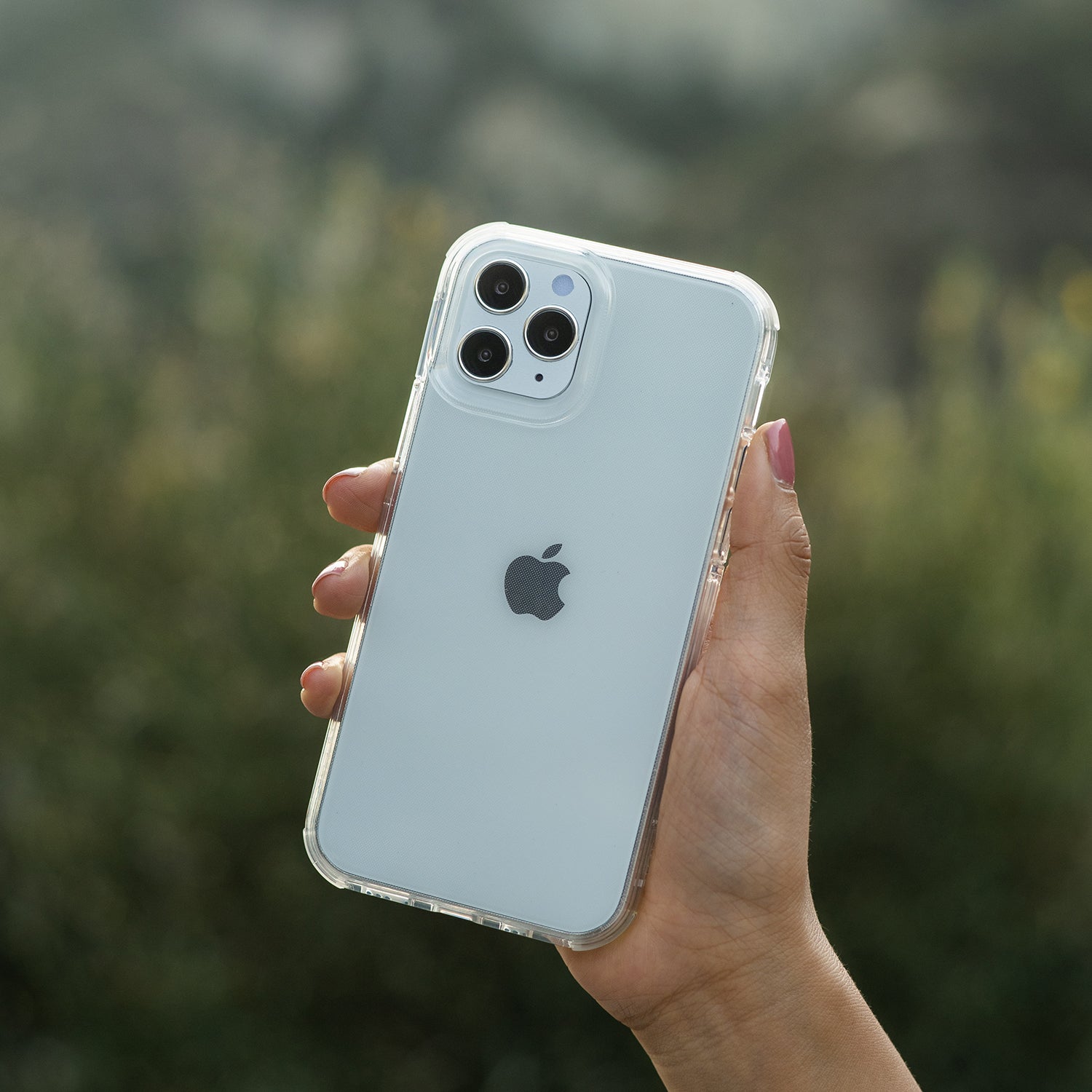 A person holding up an iPhone 13 Pro in a Raptic case with 13 foot drop protection.